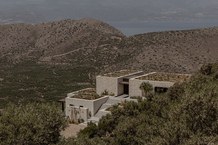 block722`s "hill house" is a cluster of stone volumes among the wild landscape of crete