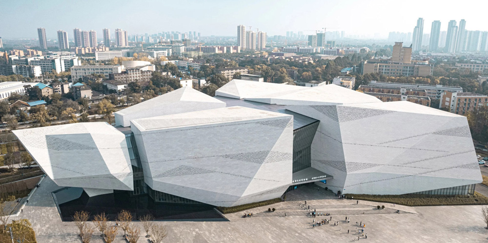 Chengdu museum of natural history resembles a monolithic landform of perforated granite